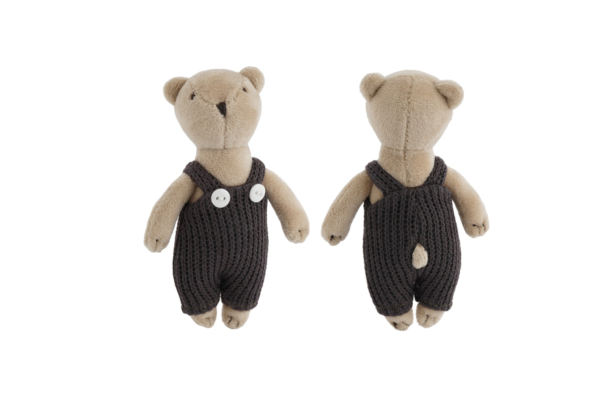 Teddy bears wearing dark knitted rompers on a white background